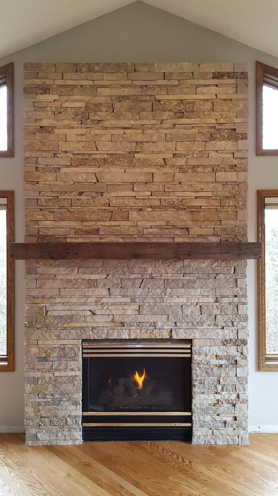 ミネアポリスにある高級な中くらいなトラディショナルスタイルのおしゃれなLDK (グレーの壁、淡色無垢フローリング、標準型暖炉、石材の暖炉まわり、ベージュの床) の写真