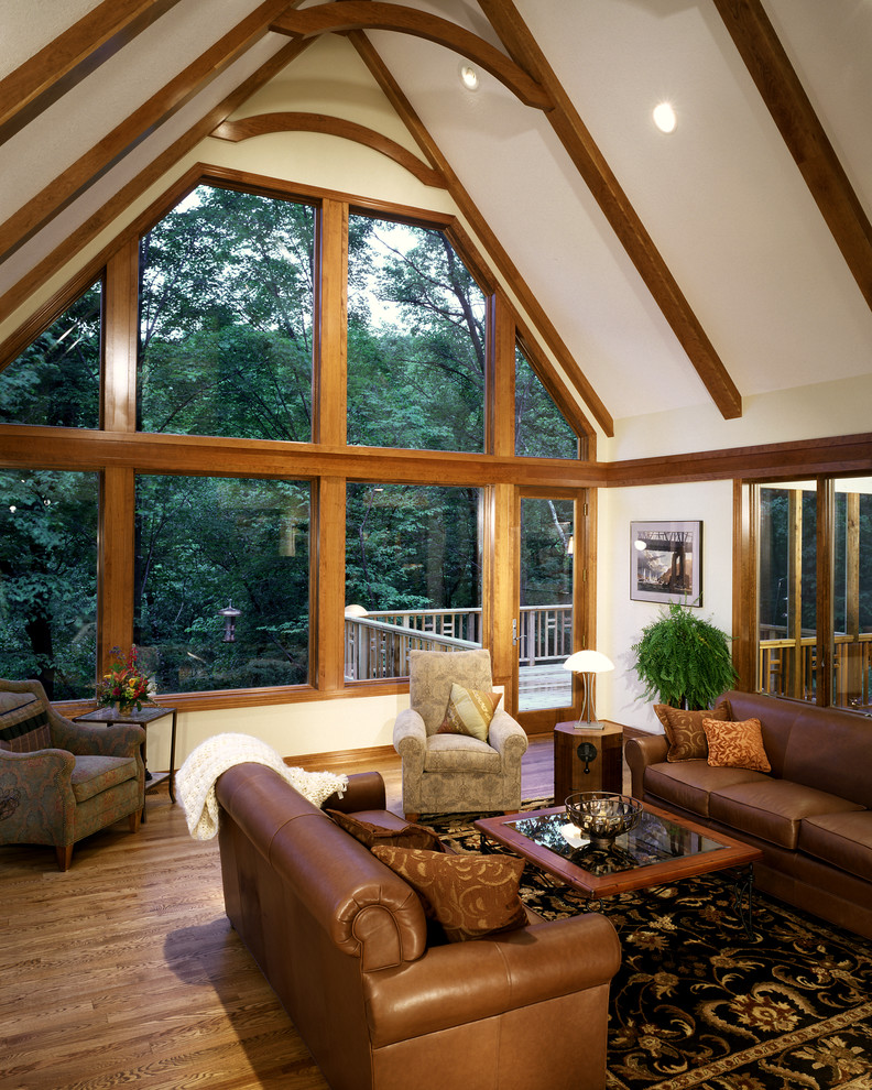Foto di un grande soggiorno tropicale stile loft con pareti beige e pavimento in legno massello medio