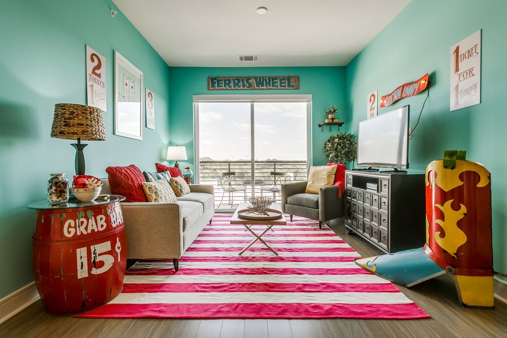 Immagine di un soggiorno boho chic con pareti verdi, pavimento in legno massello medio, TV autoportante e pavimento marrone