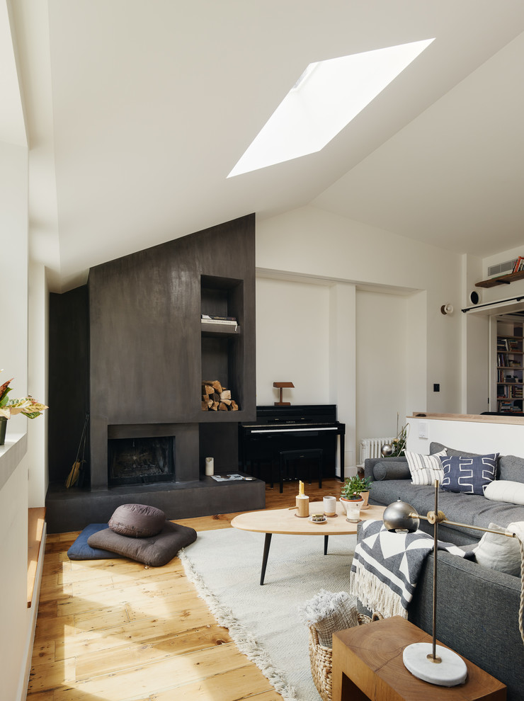 Photo of a medium sized scandi open plan living room in New York with white walls, light hardwood flooring, a standard fireplace, a metal fireplace surround and no tv.