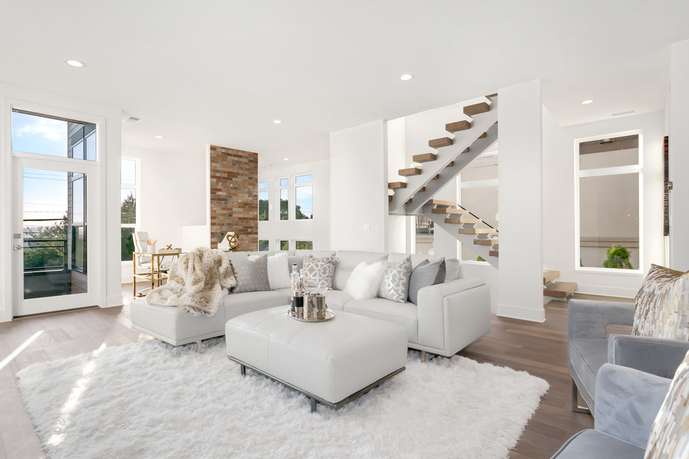 Diseño de salón abierto contemporáneo de tamaño medio sin televisor con paredes blancas, suelo de madera en tonos medios y suelo marrón