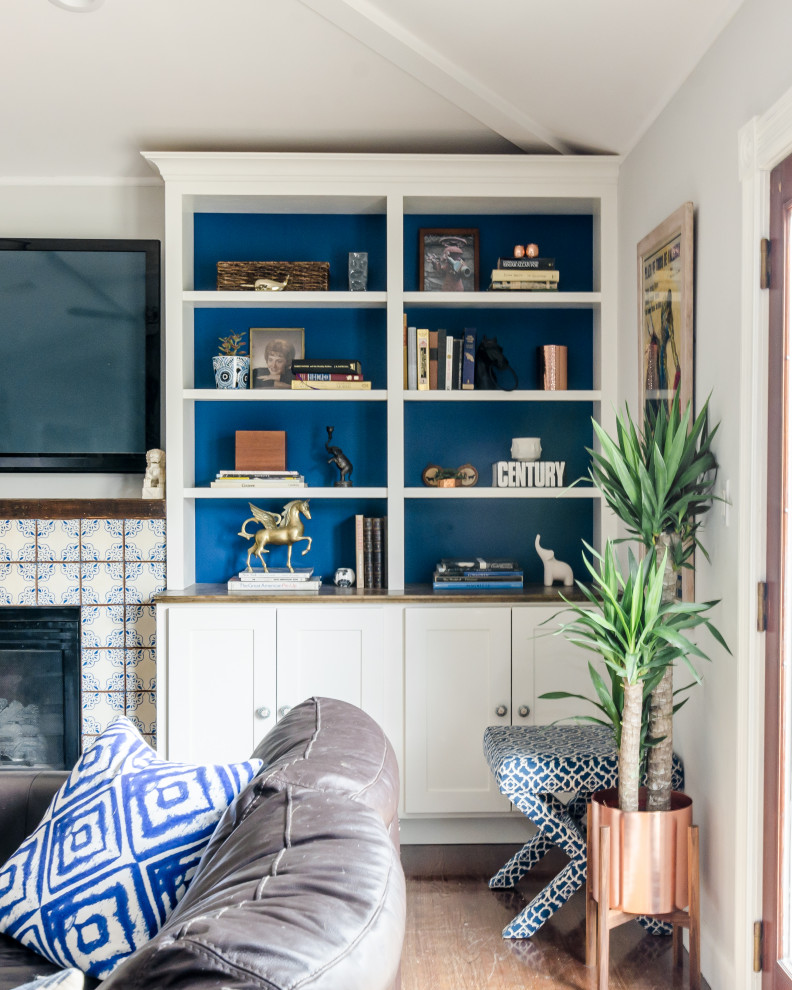 Свежая идея для дизайна: гостиная комната в современном стиле с серыми стенами, паркетным полом среднего тона, стандартным камином, фасадом камина из плитки, телевизором на стене и коричневым полом - отличное фото интерьера
