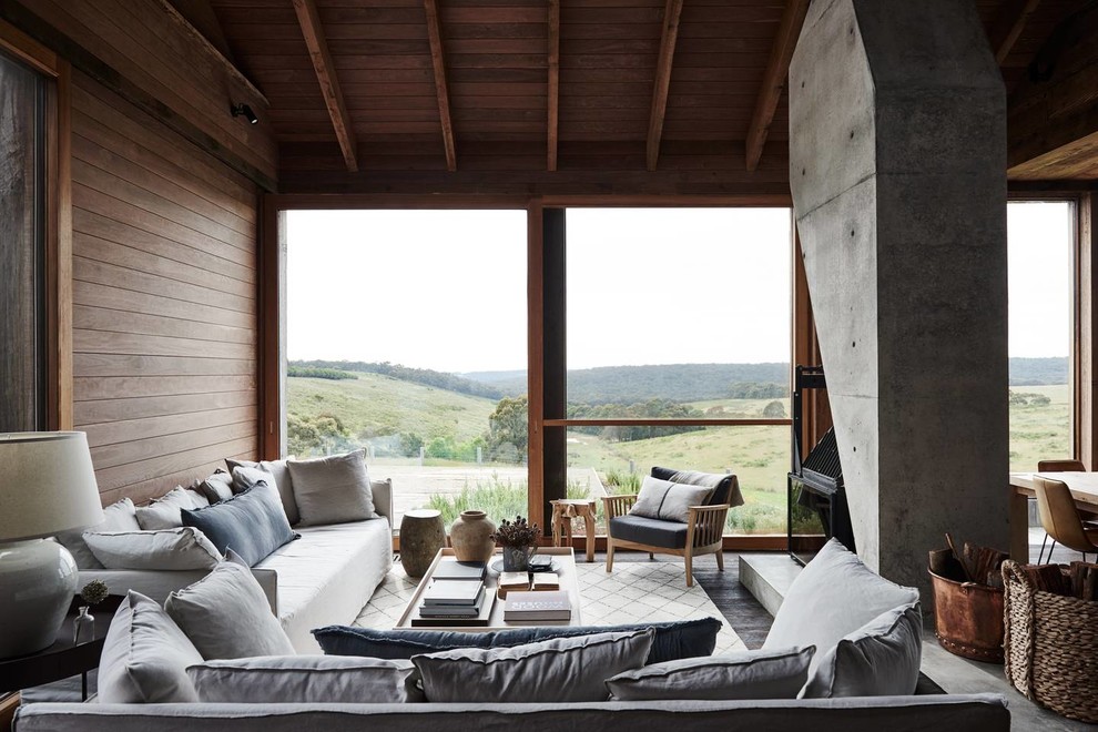 Идея дизайна: гостиная комната в стиле рустика с коричневыми стенами, бетонным полом, печью-буржуйкой и серым полом