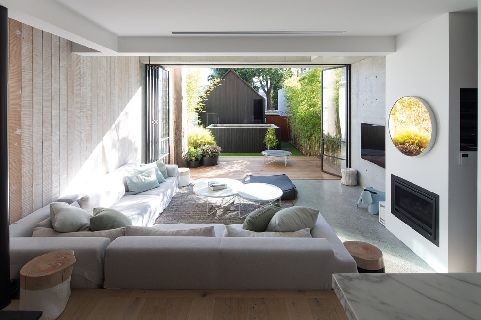 Modern inredning av ett separat vardagsrum, med betonggolv, en standard öppen spis, en spiselkrans i gips, en väggmonterad TV och grått golv