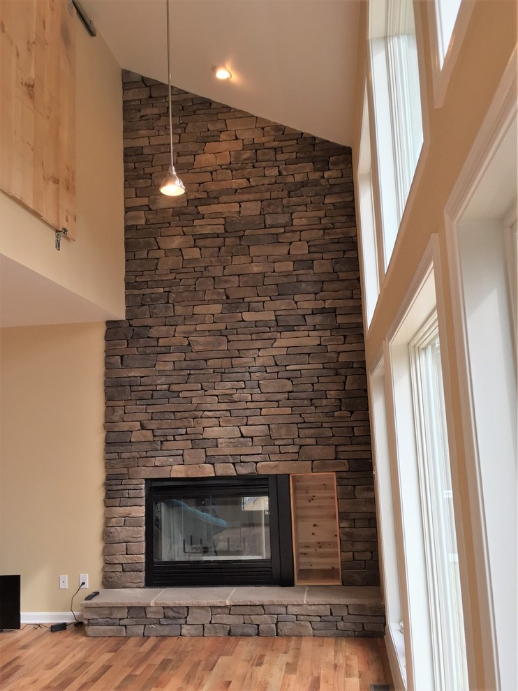 Inspiration for a mid-sized rustic formal and open concept dark wood floor and brown floor living room remodel in DC Metro with yellow walls, a standard fireplace and a stone fireplace