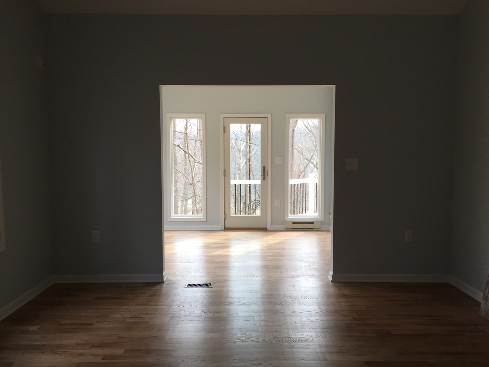 Cette image montre un salon traditionnel de taille moyenne et fermé avec un mur bleu, parquet foncé et un sol marron.