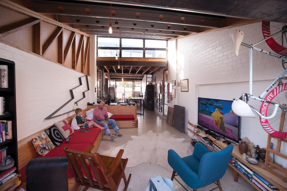 Foto di un soggiorno eclettico di medie dimensioni con pareti bianche, TV a parete e pavimento in cemento