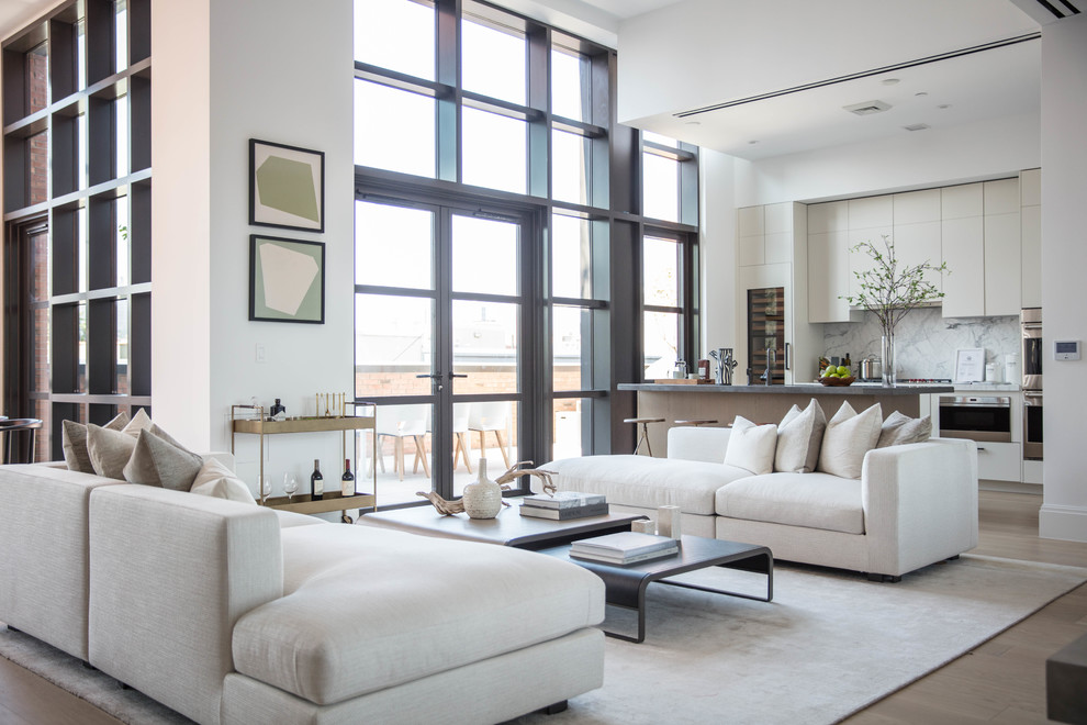 Offenes Modernes Wohnzimmer mit weißer Wandfarbe, hellem Holzboden und Hausbar in New York