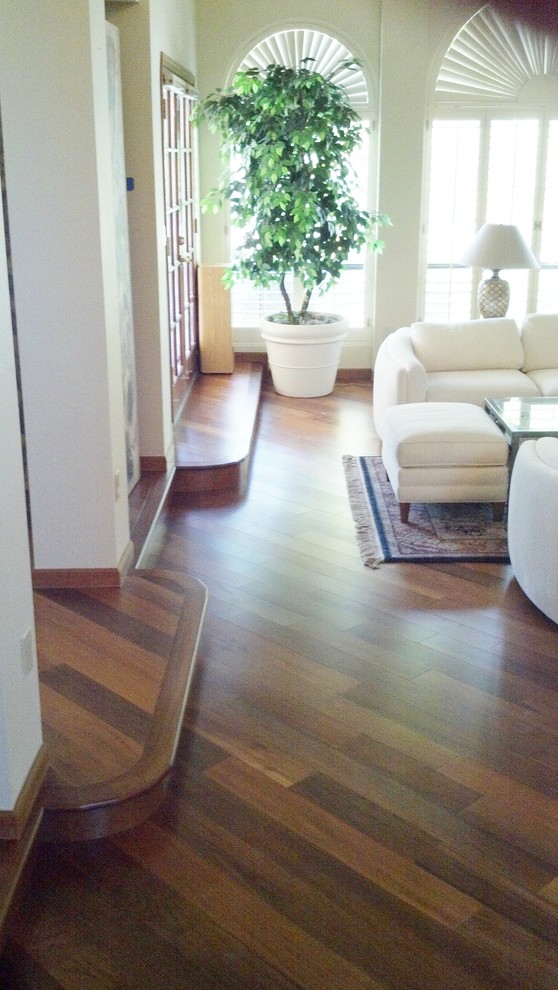 Imagen de salón contemporáneo con paredes blancas, suelo de madera en tonos medios y suelo marrón