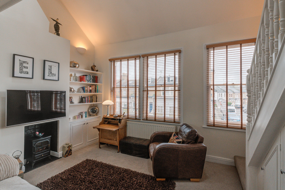 Mittelgroßes Modernes Wohnzimmer im Loft-Stil mit weißer Wandfarbe, Teppichboden, Kamin, TV-Wand und beigem Boden in London