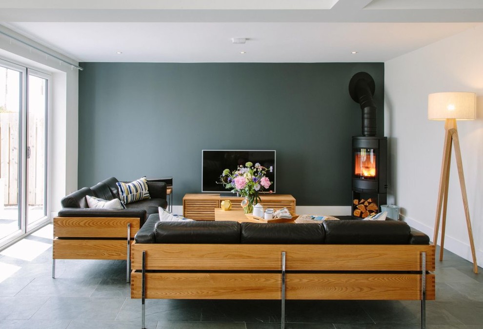 Réalisation d'un grand salon design ouvert avec une salle de réception, un mur vert, un sol en ardoise, une cheminée d'angle, un manteau de cheminée en plâtre, un téléviseur indépendant et un sol bleu.