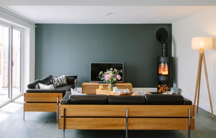 Aménagement d'un grand salon contemporain ouvert avec une salle de réception, un mur vert, un sol en ardoise, une cheminée d'angle, un manteau de cheminée en plâtre, un téléviseur indépendant et un sol bleu.