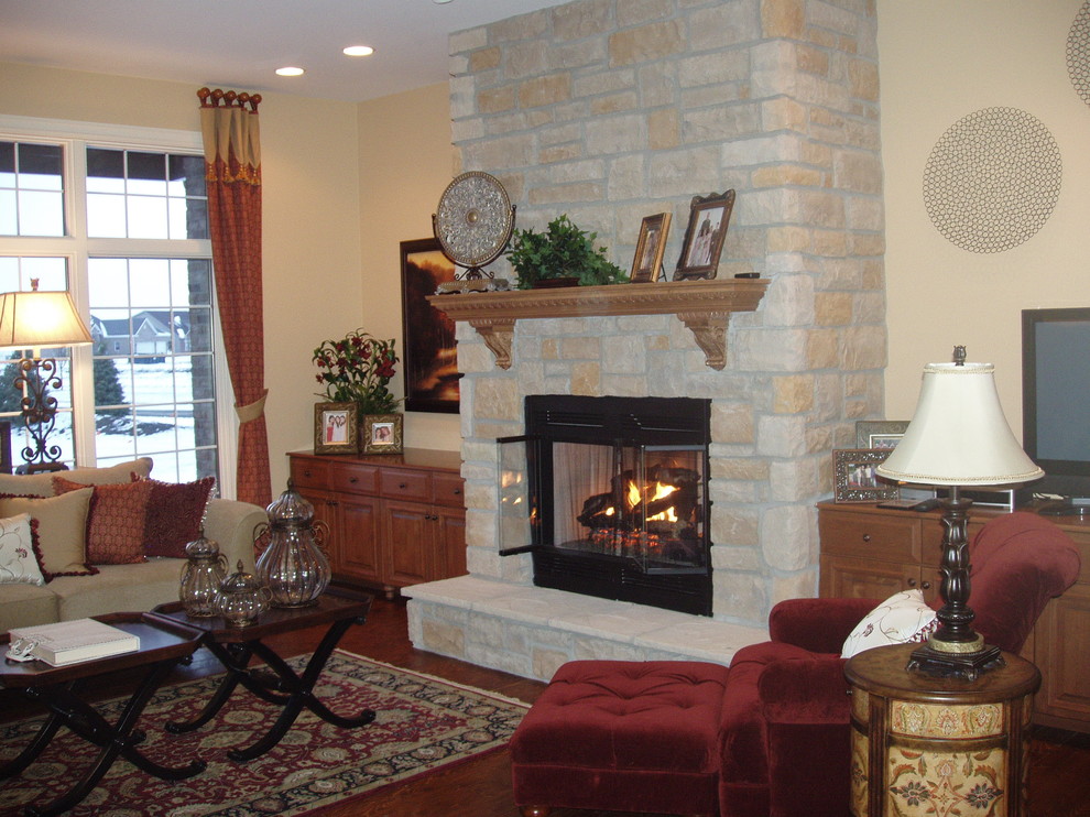 Klassisches Wohnzimmer mit braunem Holzboden, Kamin und Kaminumrandung aus Stein in Chicago