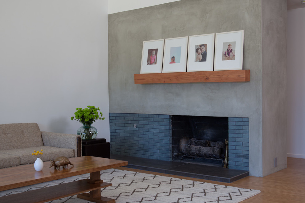 Offenes Retro Wohnzimmer mit weißer Wandfarbe, hellem Holzboden und Kamin in Los Angeles