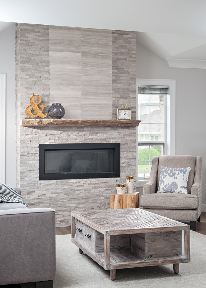 Mid-sized transitional formal and enclosed medium tone wood floor living room photo in Vancouver with gray walls, a standard fireplace, a stone fireplace and a wall-mounted tv