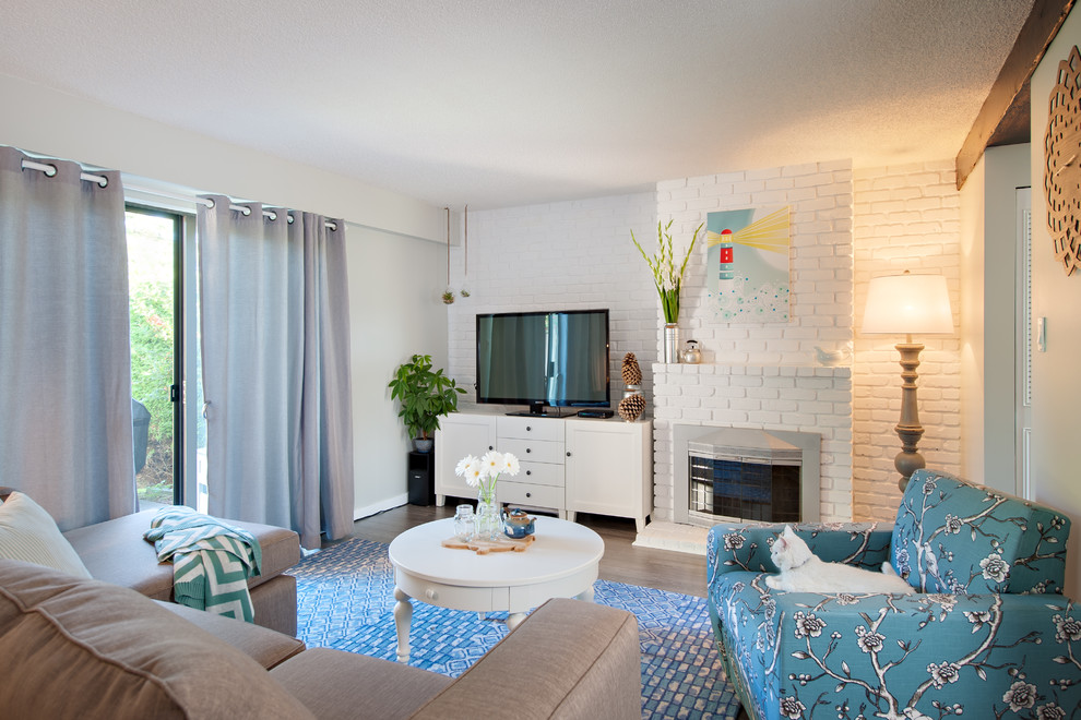 Esempio di un soggiorno classico con cornice del camino in mattoni e TV autoportante