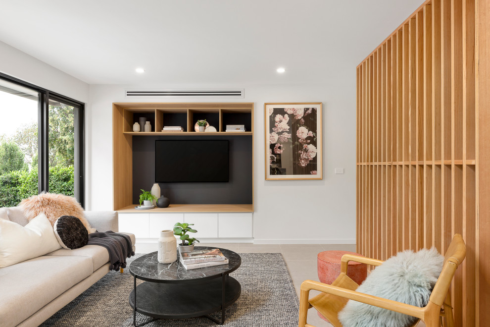 Стильный дизайн: гостиная комната в скандинавском стиле с белыми стенами, телевизором на стене и серым полом - последний тренд