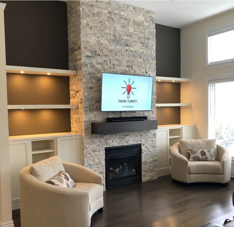 Foto di un soggiorno design di medie dimensioni e aperto con pareti marroni, camino classico, TV a parete e pavimento marrone