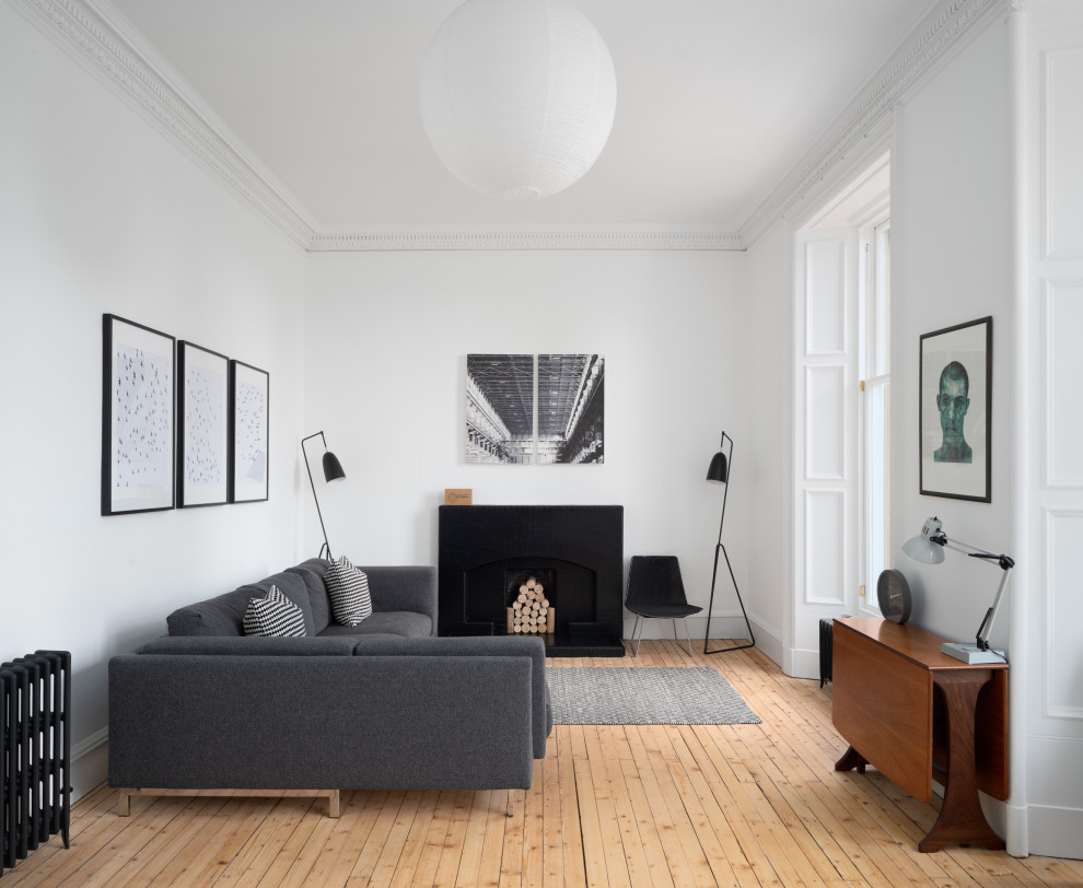 This is an example of a medium sized scandinavian formal enclosed living room in Edinburgh with white walls, medium hardwood flooring, no tv and beige floors.
