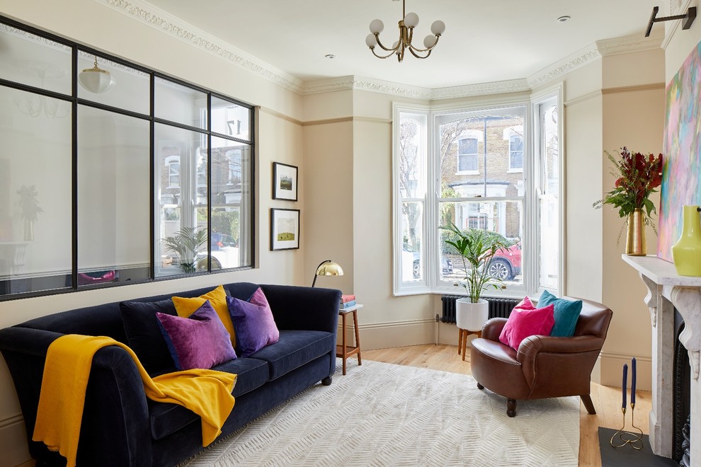 Classic enclosed living room in London with beige walls, light hardwood flooring, a standard fireplace and beige floors.