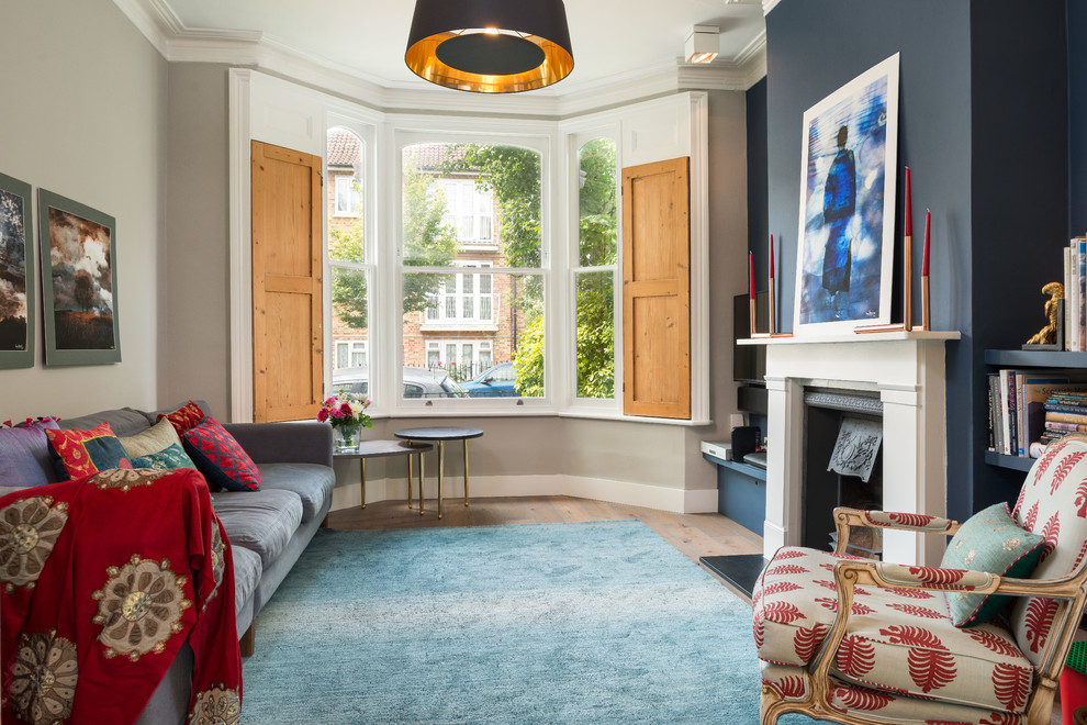 Idee per un soggiorno minimal di medie dimensioni con sala formale, pareti blu, camino classico e TV a parete