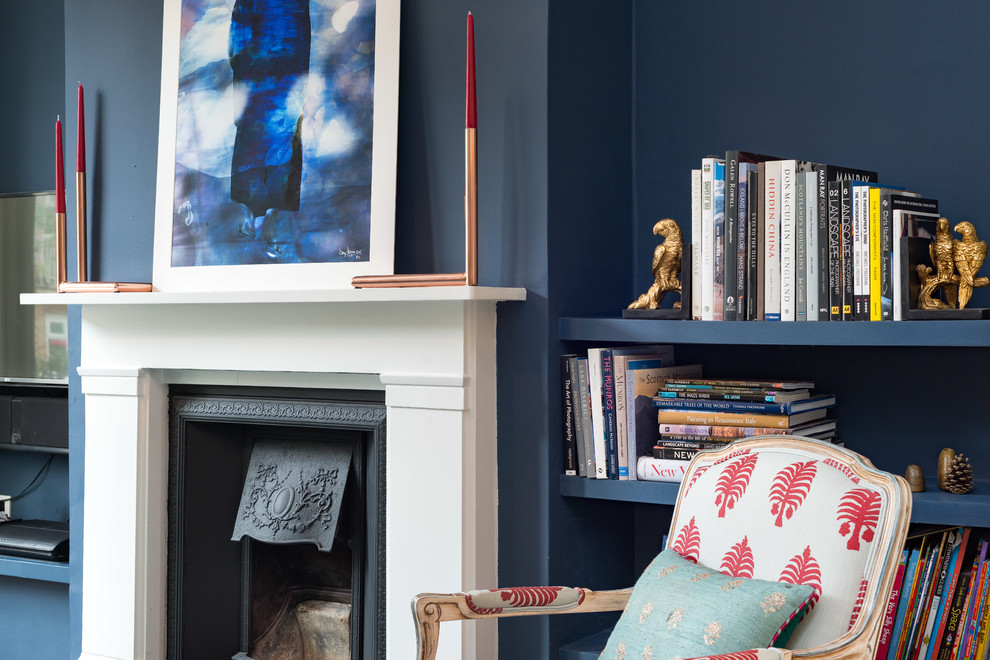 ロンドンにあるラグジュアリーな中くらいなミッドセンチュリースタイルのおしゃれなリビング (青い壁、無垢フローリング、木材の暖炉まわり、壁掛け型テレビ) の写真