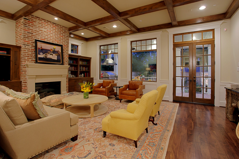 This is an example of a large traditional formal enclosed living room in Houston with beige walls, dark hardwood flooring, a standard fireplace, a brick fireplace surround and no tv.