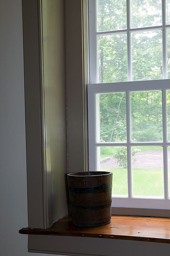 Abgetrenntes Country Wohnzimmer mit weißer Wandfarbe, braunem Holzboden, Kamin und Kaminumrandung aus Stein in Philadelphia
