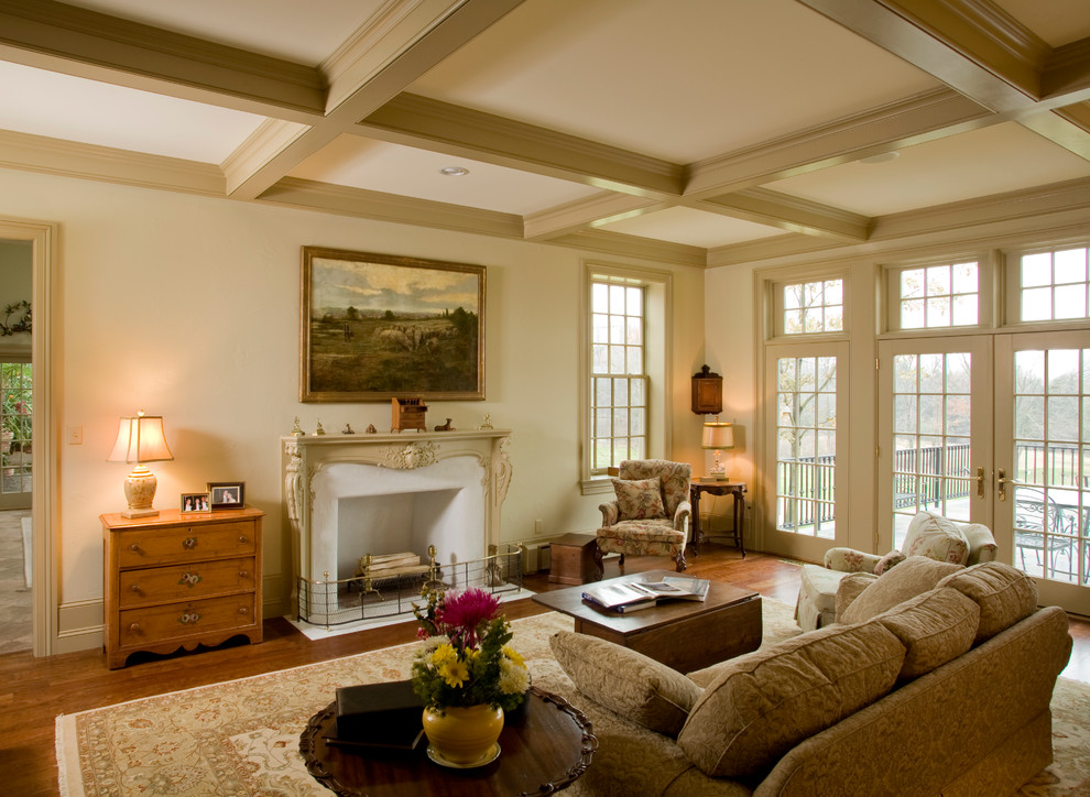 Exemple d'un salon chic avec une salle de réception, un mur beige, un sol en bois brun et une cheminée standard.