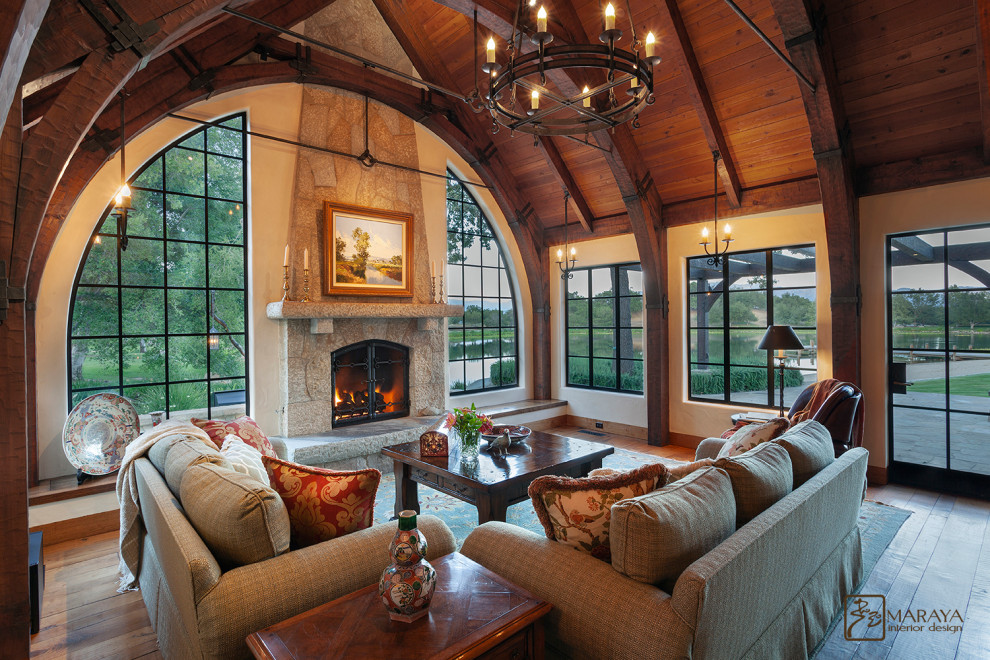 Inspiration for a medium sized country mezzanine living room in Santa Barbara with a reading nook, beige walls, medium hardwood flooring, a standard fireplace, a stone fireplace surround, a concealed tv and brown floors.