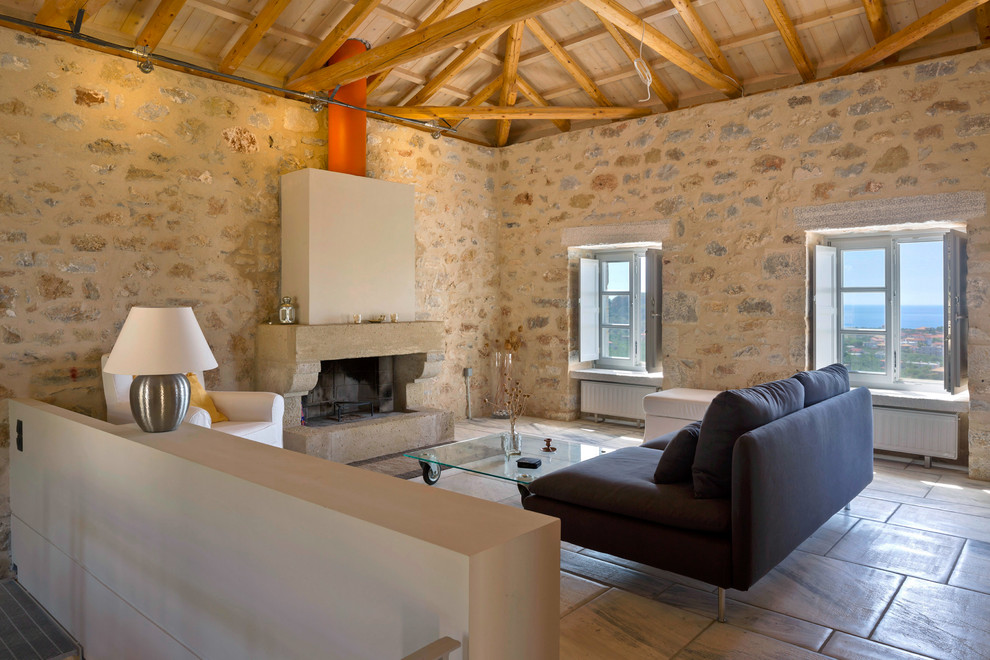 Mediterranes Wohnzimmer mit Kamin und Steinwänden in Sonstige