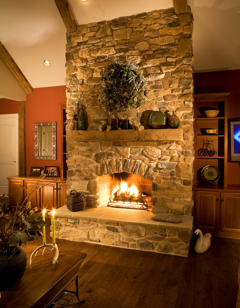 Example of a large mountain style open concept dark wood floor and brown floor living room design in St Louis with brown walls, a standard fireplace, a stone fireplace and no tv