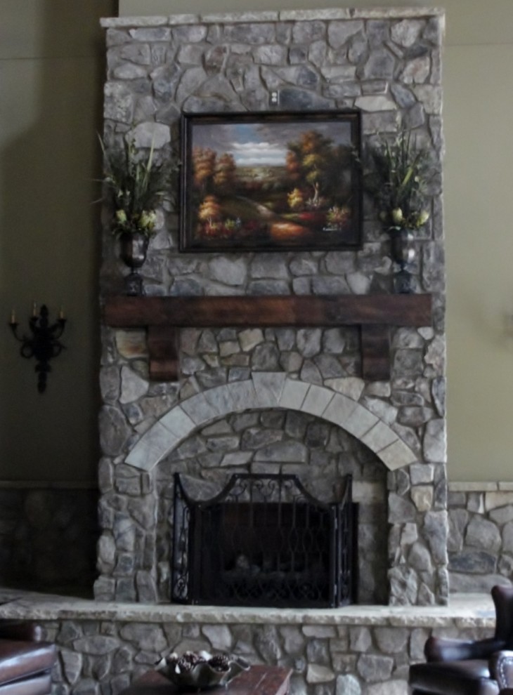 アトランタにあるお手頃価格の中くらいなラスティックスタイルのおしゃれなリビング (緑の壁、標準型暖炉、石材の暖炉まわり、テレビなし) の写真