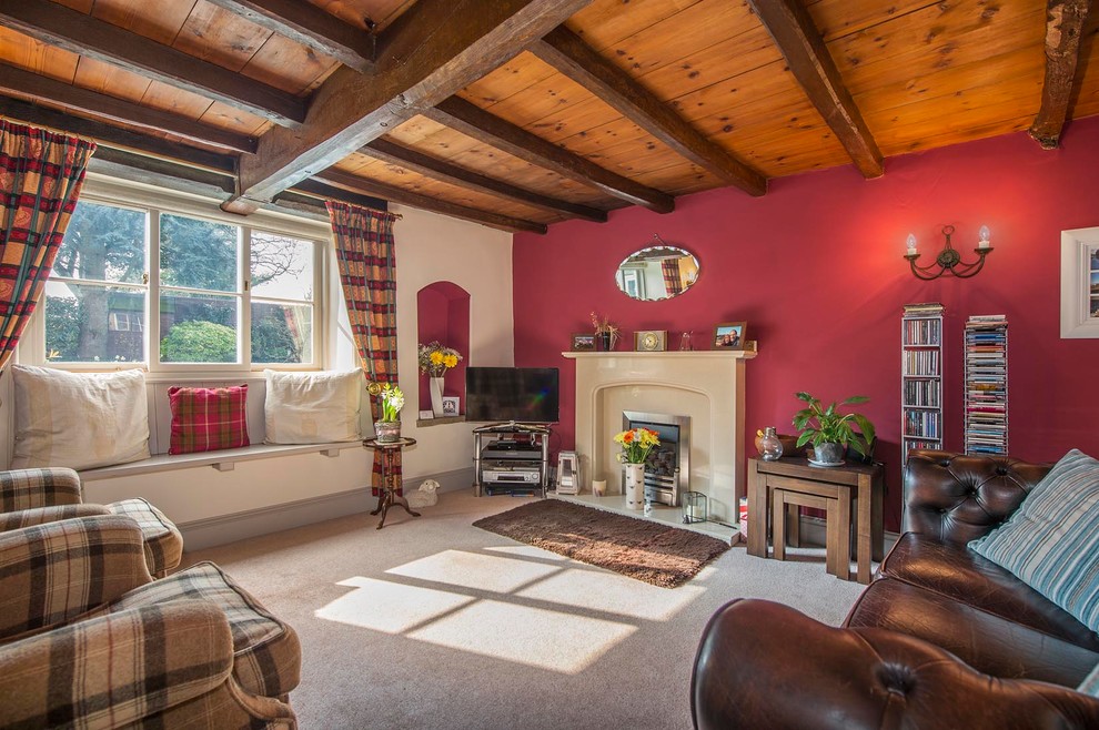 Foto de salón de estilo de casa de campo con paredes rojas, moqueta, todas las chimeneas y televisor independiente