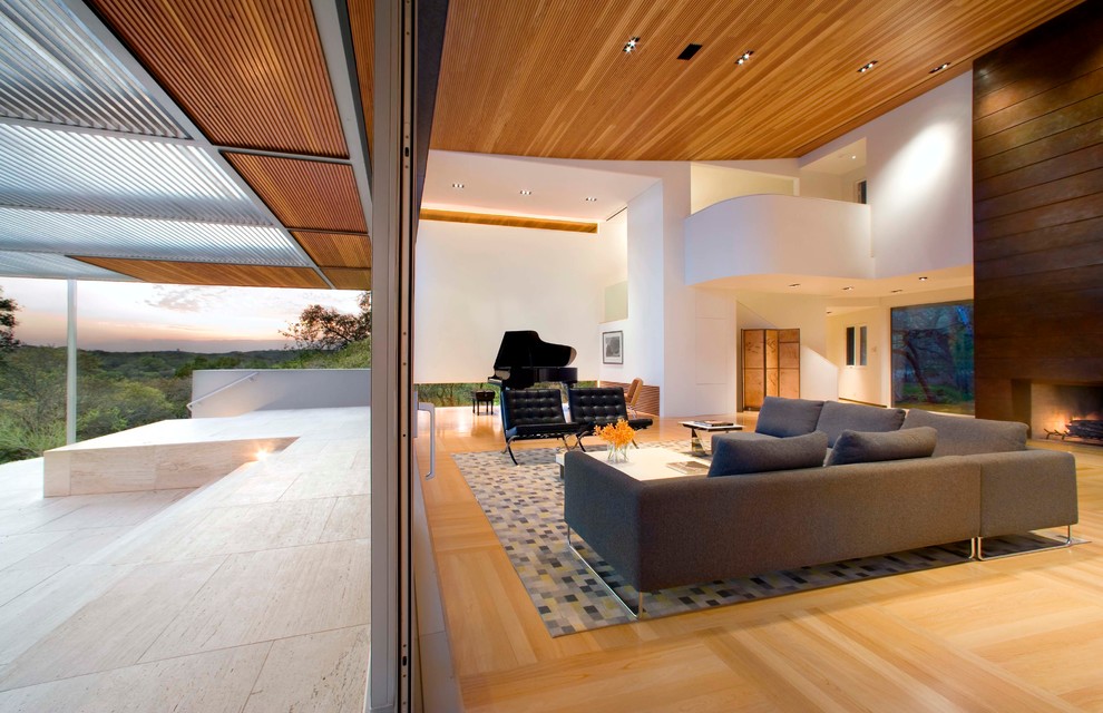 Example of a trendy open concept light wood floor living room design in Austin with white walls, a standard fireplace, a metal fireplace and no tv