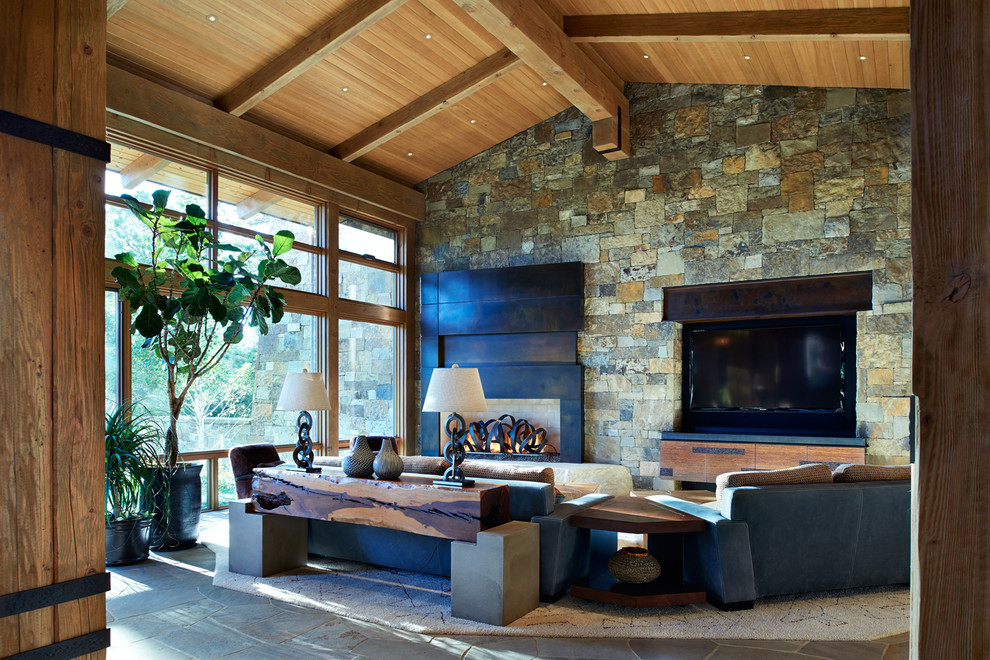 Cette photo montre un grand salon montagne ouvert avec une salle de réception, un mur multicolore, une cheminée standard, un manteau de cheminée en métal et un téléviseur encastré.