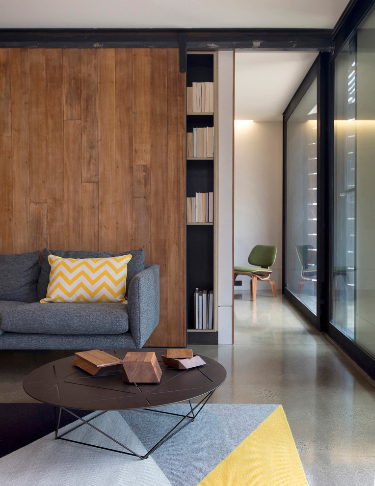 Источник вдохновения для домашнего уюта: открытая гостиная комната в современном стиле с белыми стенами, бетонным полом и с книжными шкафами и полками