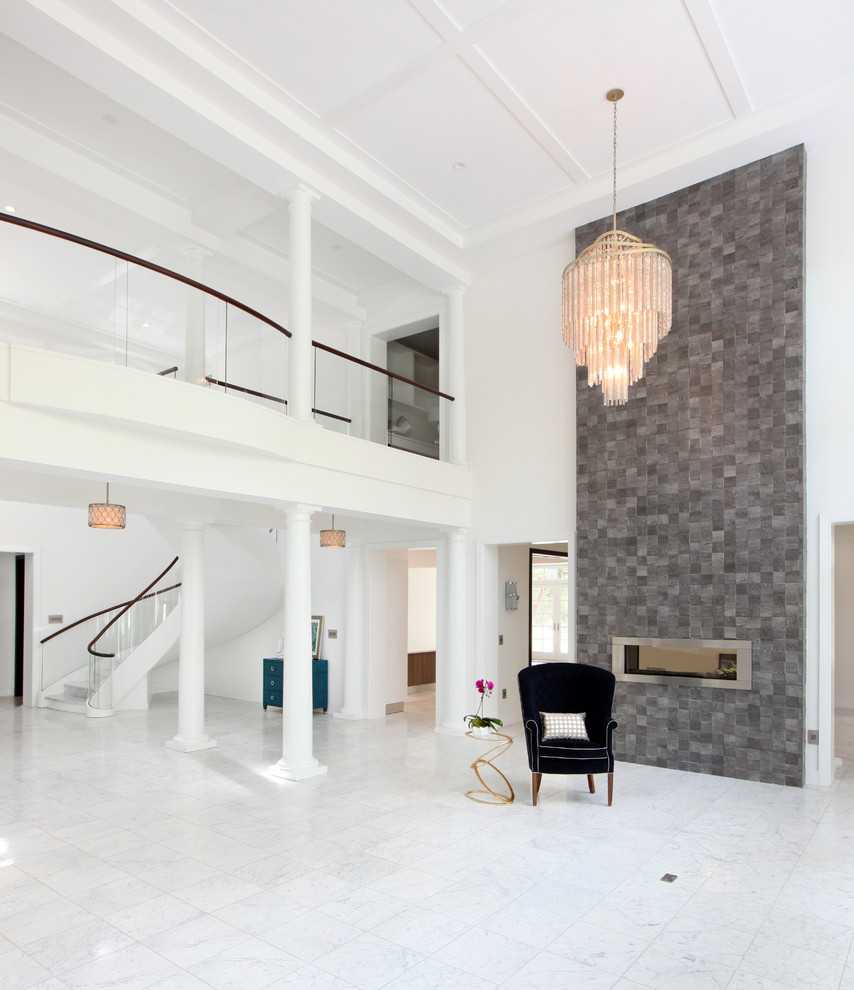 Свежая идея для дизайна: огромная парадная, открытая гостиная комната в стиле модернизм с белыми стенами, мраморным полом, двусторонним камином, фасадом камина из камня и белым полом без телевизора - отличное фото интерьера