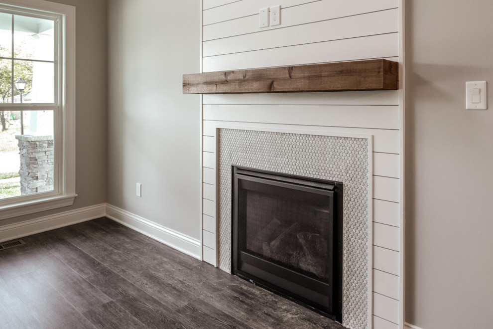 Offenes Klassisches Wohnzimmer mit braunem Holzboden, Kamin, Kaminumrandung aus Holzdielen und grauem Boden in Louisville