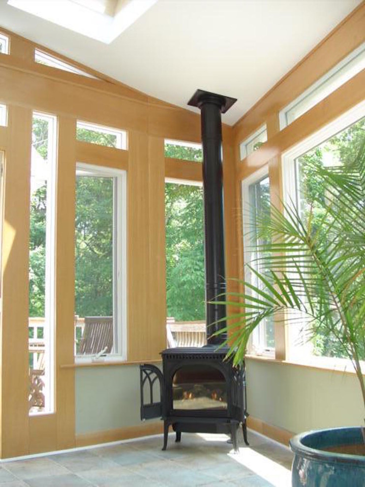 Modelo de salón tradicional de tamaño medio con suelo de pizarra, estufa de leña y marco de chimenea de metal
