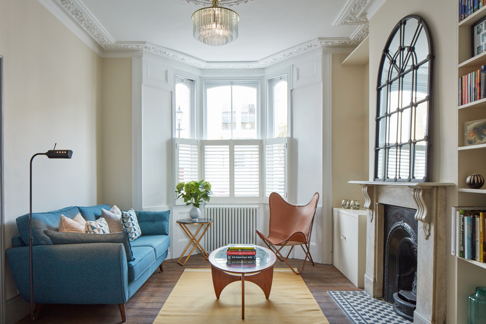 Repräsentatives, Fernseherloses, Abgetrenntes Klassisches Wohnzimmer mit beiger Wandfarbe, dunklem Holzboden, Kamin und Kaminumrandung aus Stein in London
