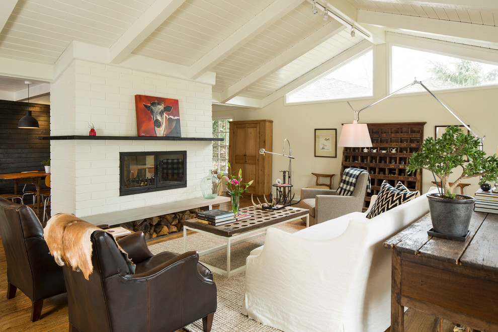 Landhaus Wohnzimmer mit weißer Wandfarbe, braunem Holzboden, Kamin und Kaminumrandung aus Backstein in Minneapolis