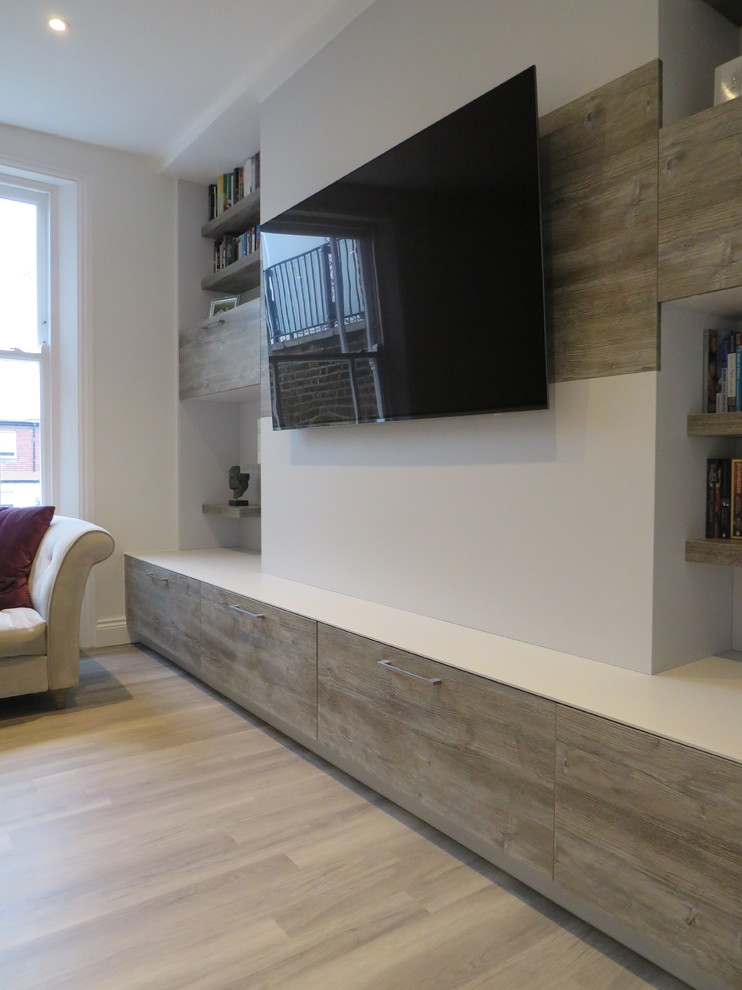 Идея дизайна: изолированная гостиная комната среднего размера в современном стиле с серыми стенами, полом из винила, телевизором на стене и серым полом