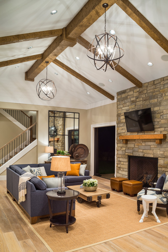 Пример оригинального дизайна: гостиная комната в стиле неоклассика (современная классика) с бежевыми стенами, стандартным камином, фасадом камина из камня, телевизором на стене и ковром на полу