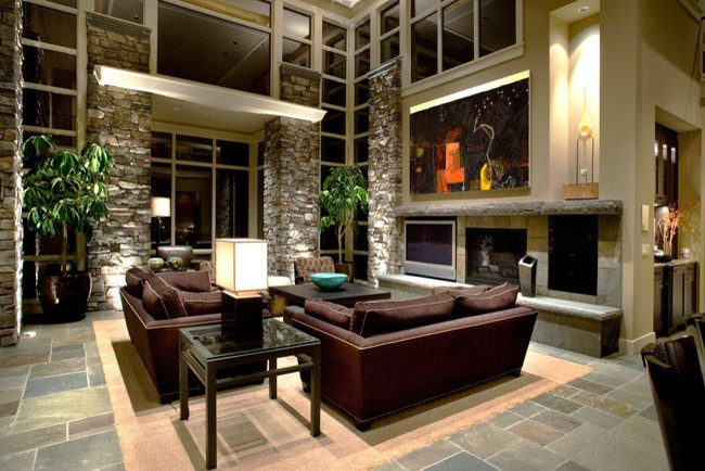 Foto di un ampio soggiorno design aperto con pareti beige, pavimento in ardesia, camino classico e TV a parete