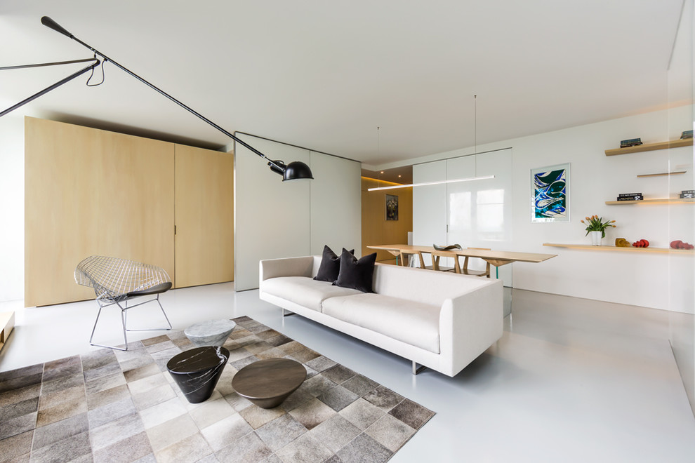 Inspiration pour un salon minimaliste ouvert avec un mur blanc et un sol blanc.