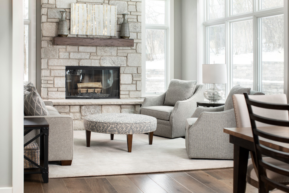 Mid-sized elegant formal and enclosed medium tone wood floor and brown floor living room photo in Milwaukee with gray walls, a standard fireplace, a stone fireplace and no tv