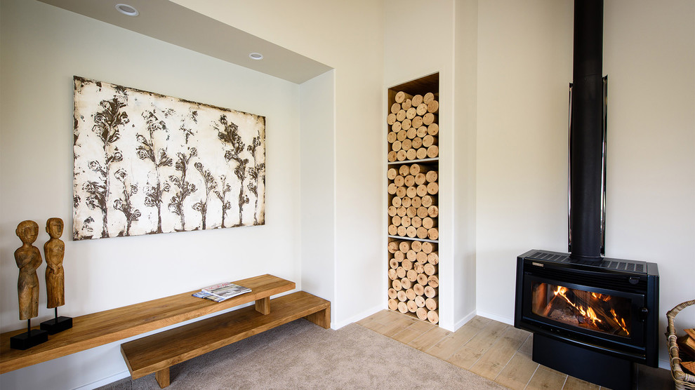 Modelo de salón para visitas abierto actual grande con paredes beige, moqueta y estufa de leña