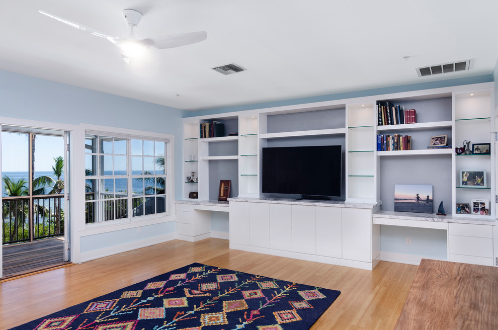 Imagen de salón cerrado contemporáneo grande sin chimenea con paredes azules, suelo de madera clara, pared multimedia y suelo beige