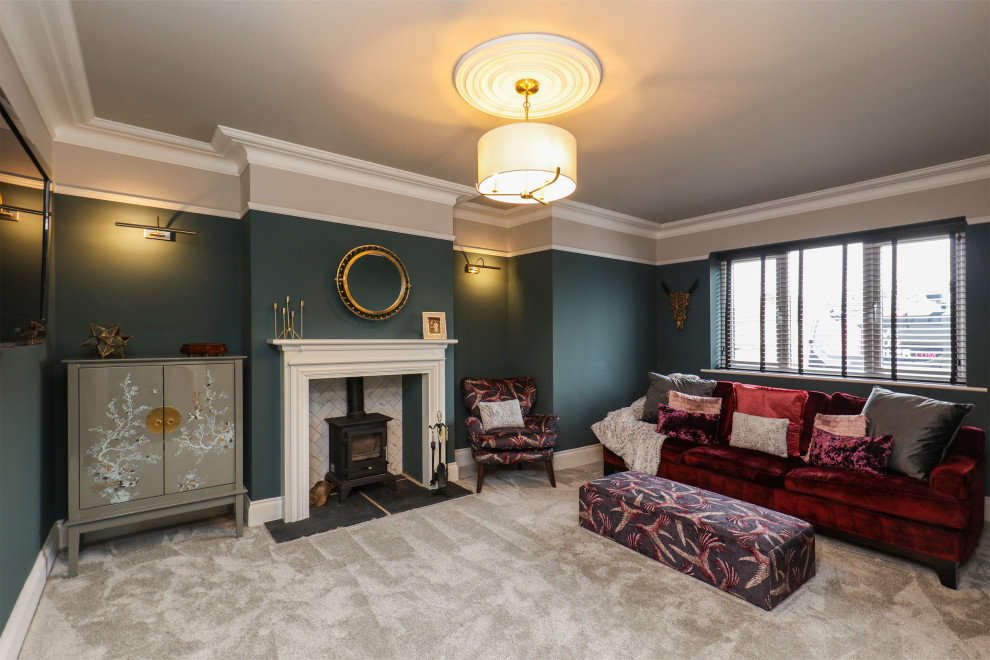 Пример оригинального дизайна: изолированная гостиная комната среднего размера в стиле неоклассика (современная классика) с синими стенами, ковровым покрытием, печью-буржуйкой, фасадом камина из дерева, телевизором на стене и серым полом